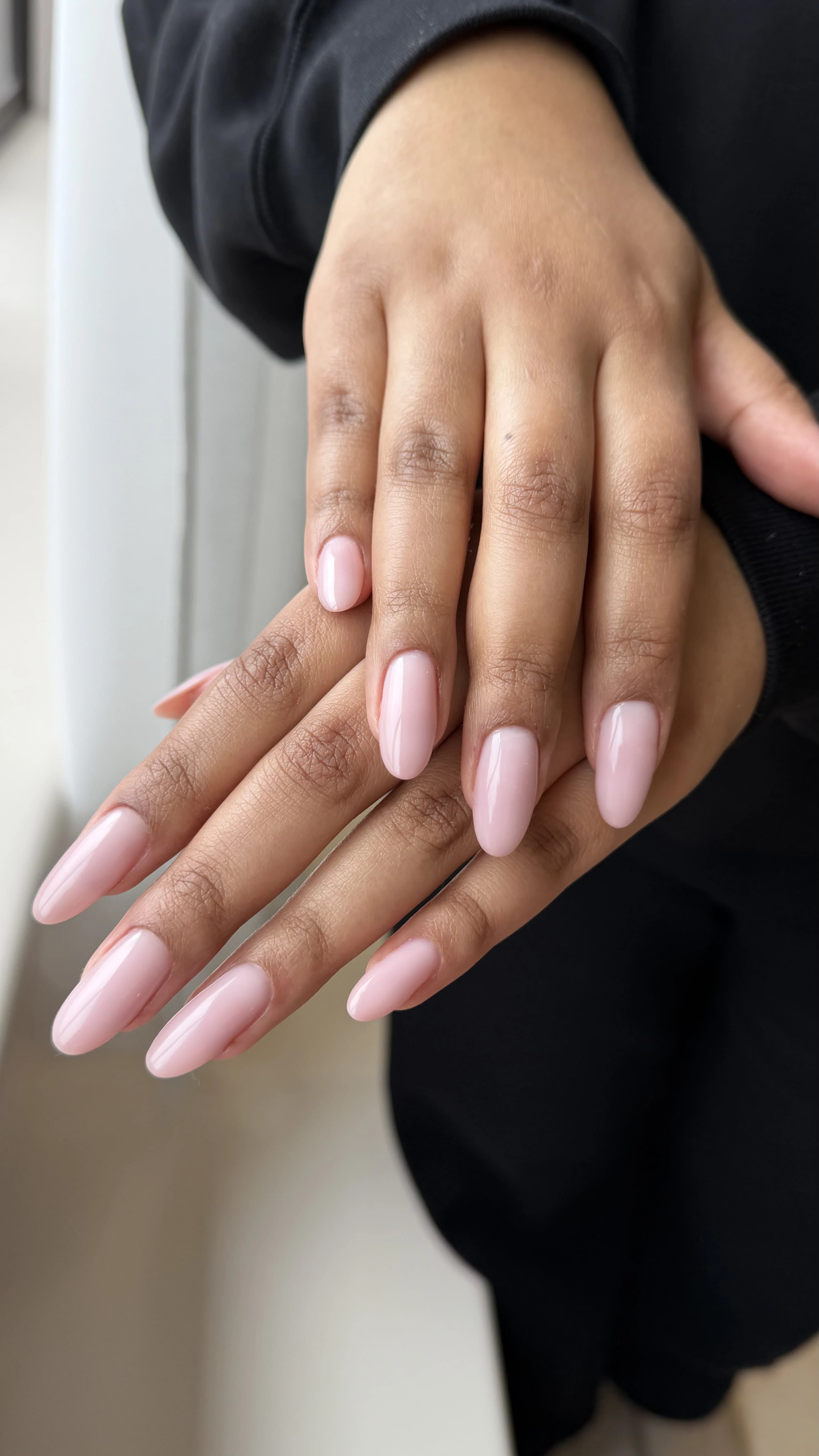 Hard gel extensions at My Beauty Space: long almond nails in semi-sheer milky pink gloss with overlapping hands.