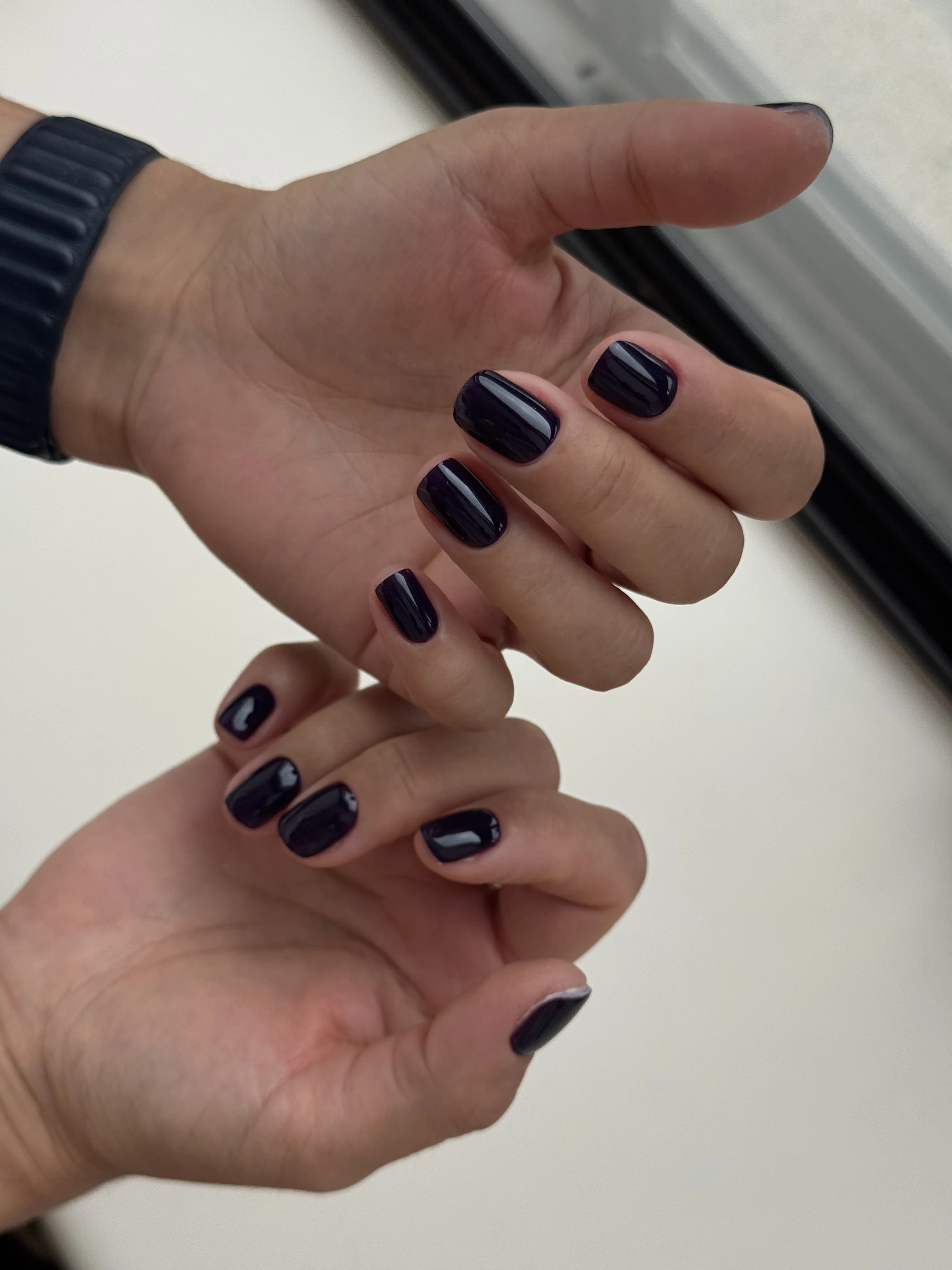 Deep midnight-purple gel polish on short squoval nails with a navy watch strap, from My Beauty Space nail care in Mississauga.