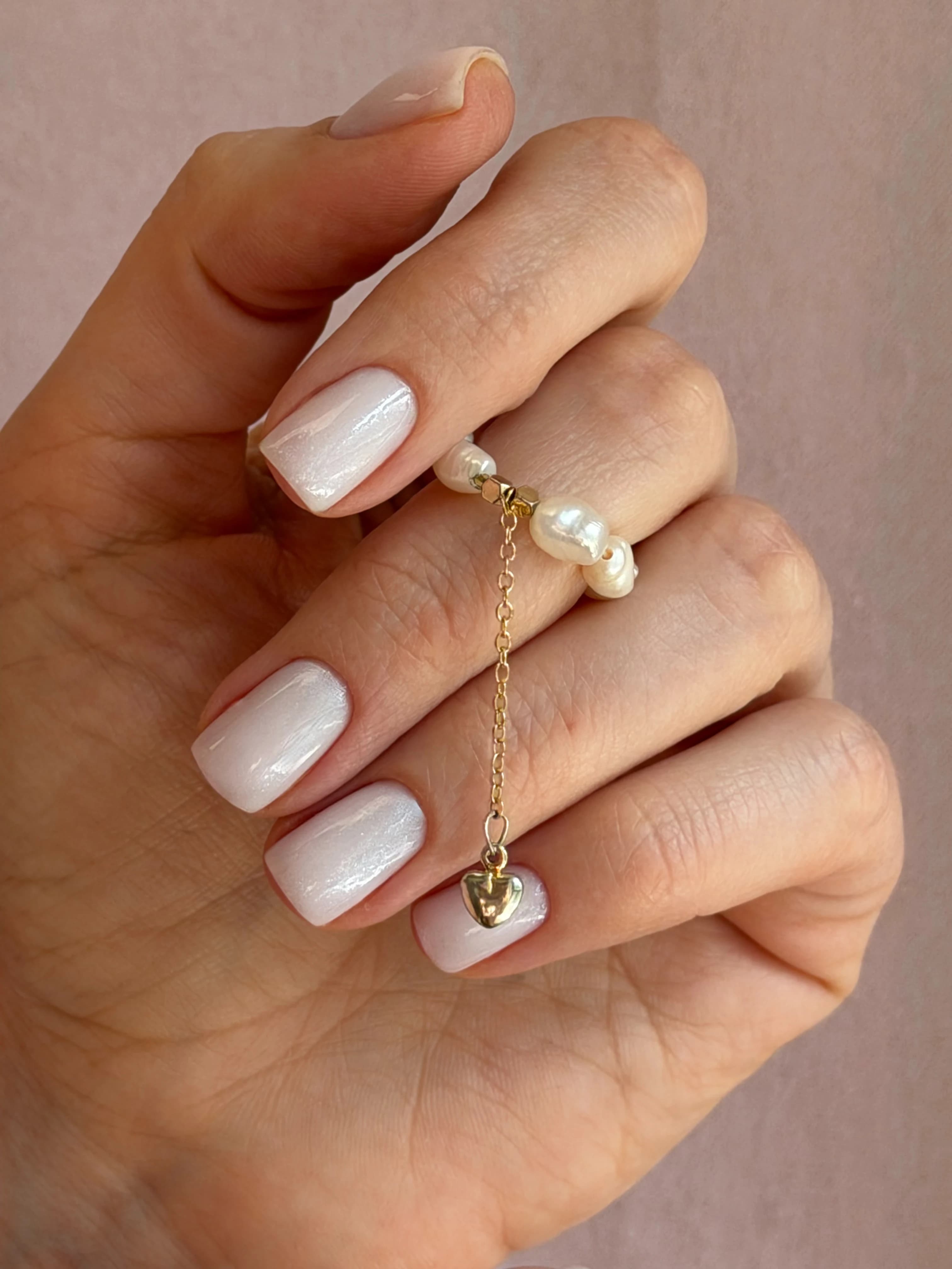 Pearlescent milky white gel polish on squoval nails with a pearl heart ring, done at My Beauty Space nail salon in Mississauga.