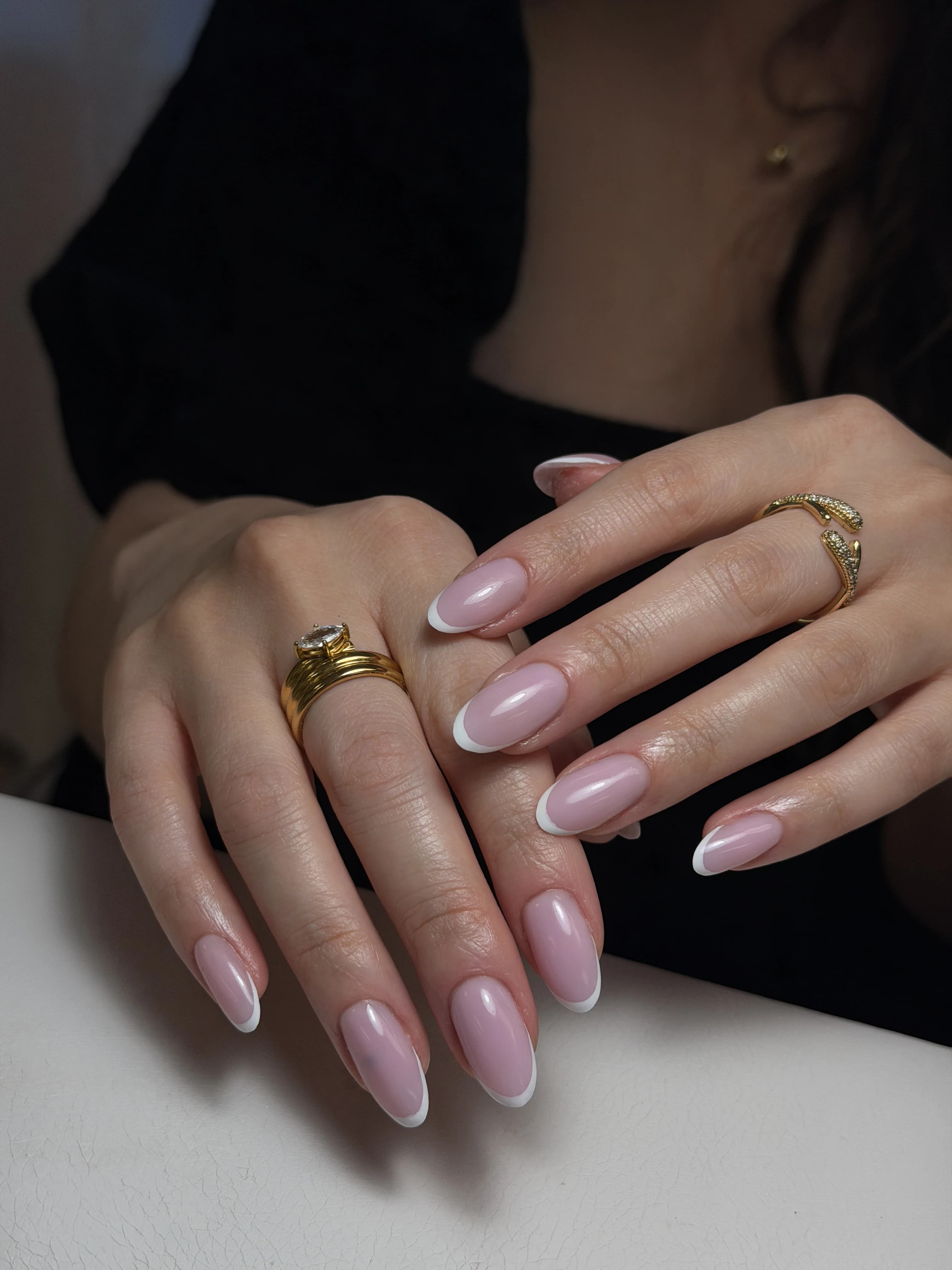 Long oval hard gel French manicure at My Beauty Space: sheer nude-pink base, crisp white tips, gold rings.