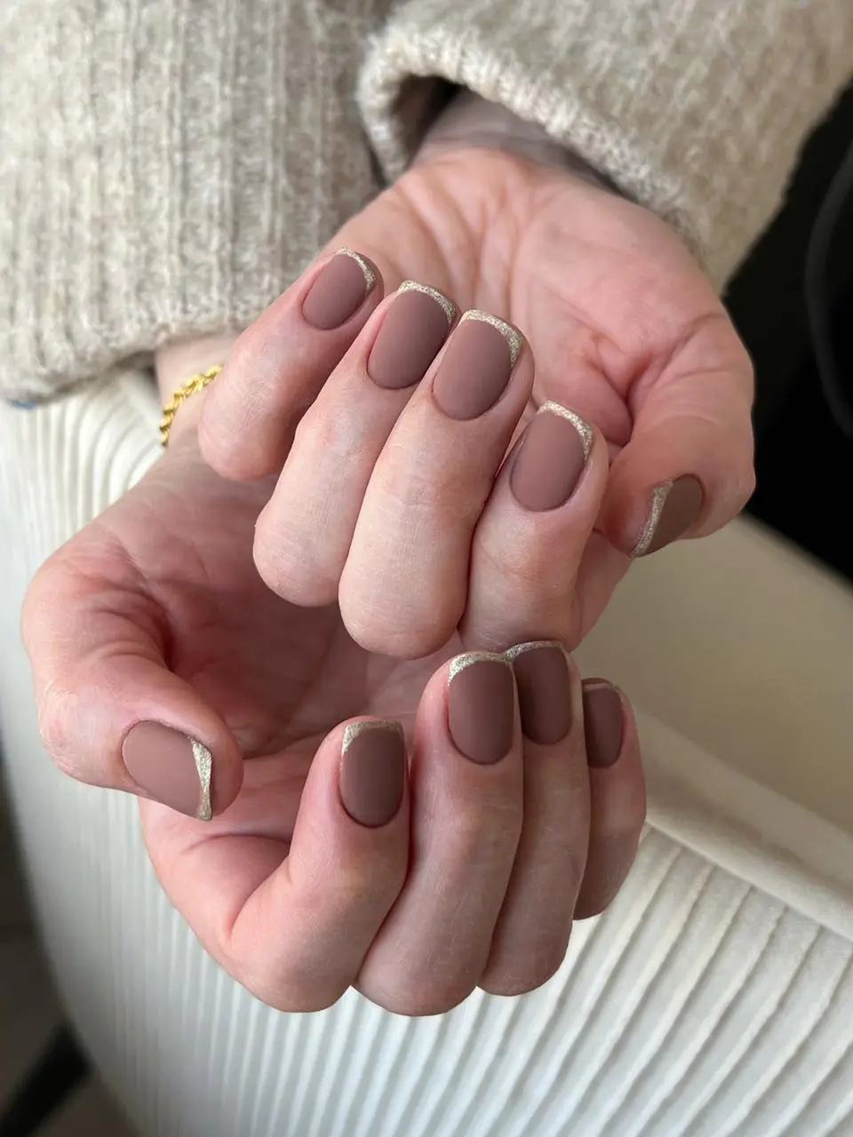 Short squoval manicure with matte mauve polish and gold glitter micro-French tips at My Beauty Space