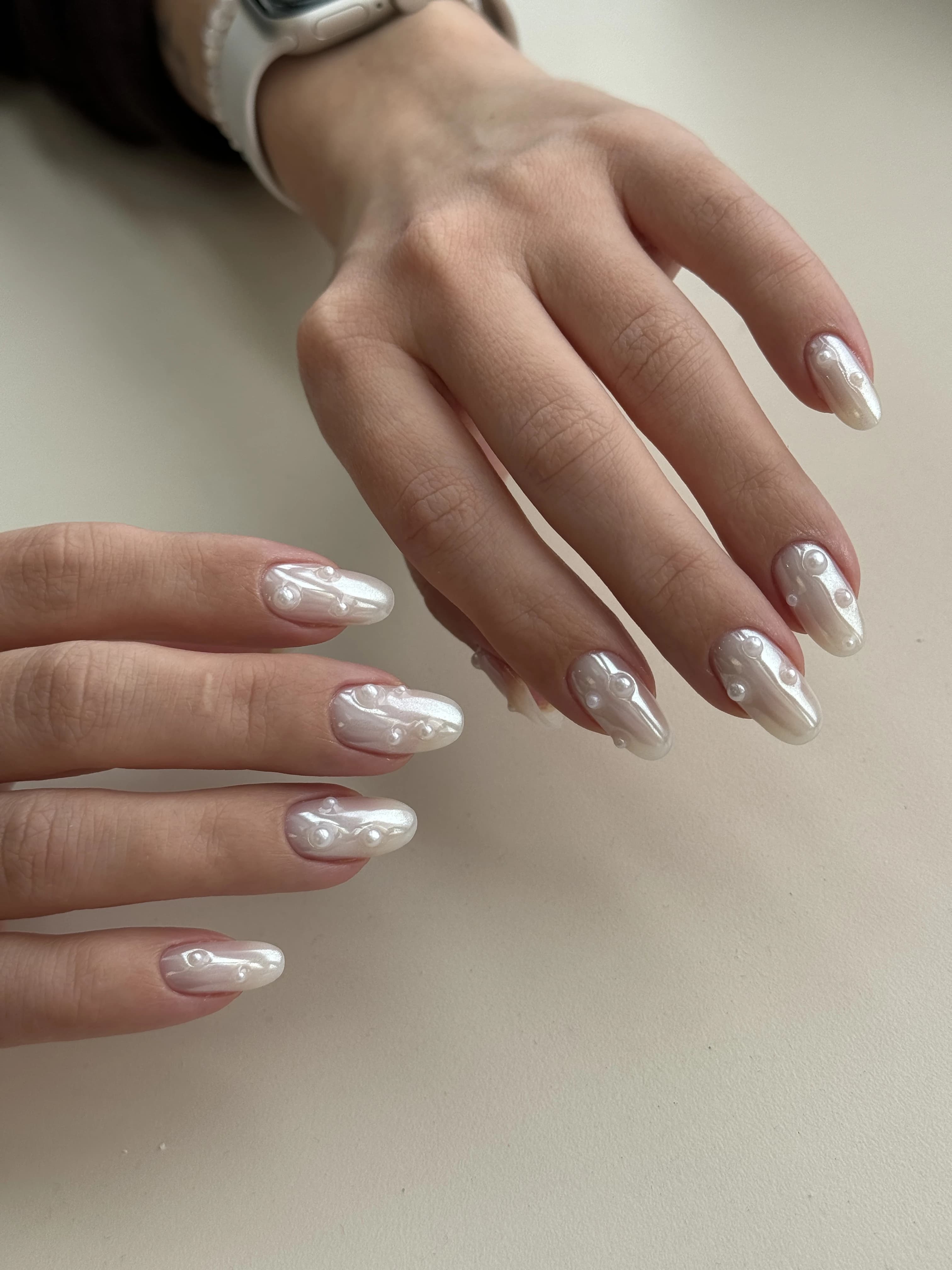 Hard gel almond nails at My Beauty Space with iridescent white chrome and scattered 3D pearl embellishments.