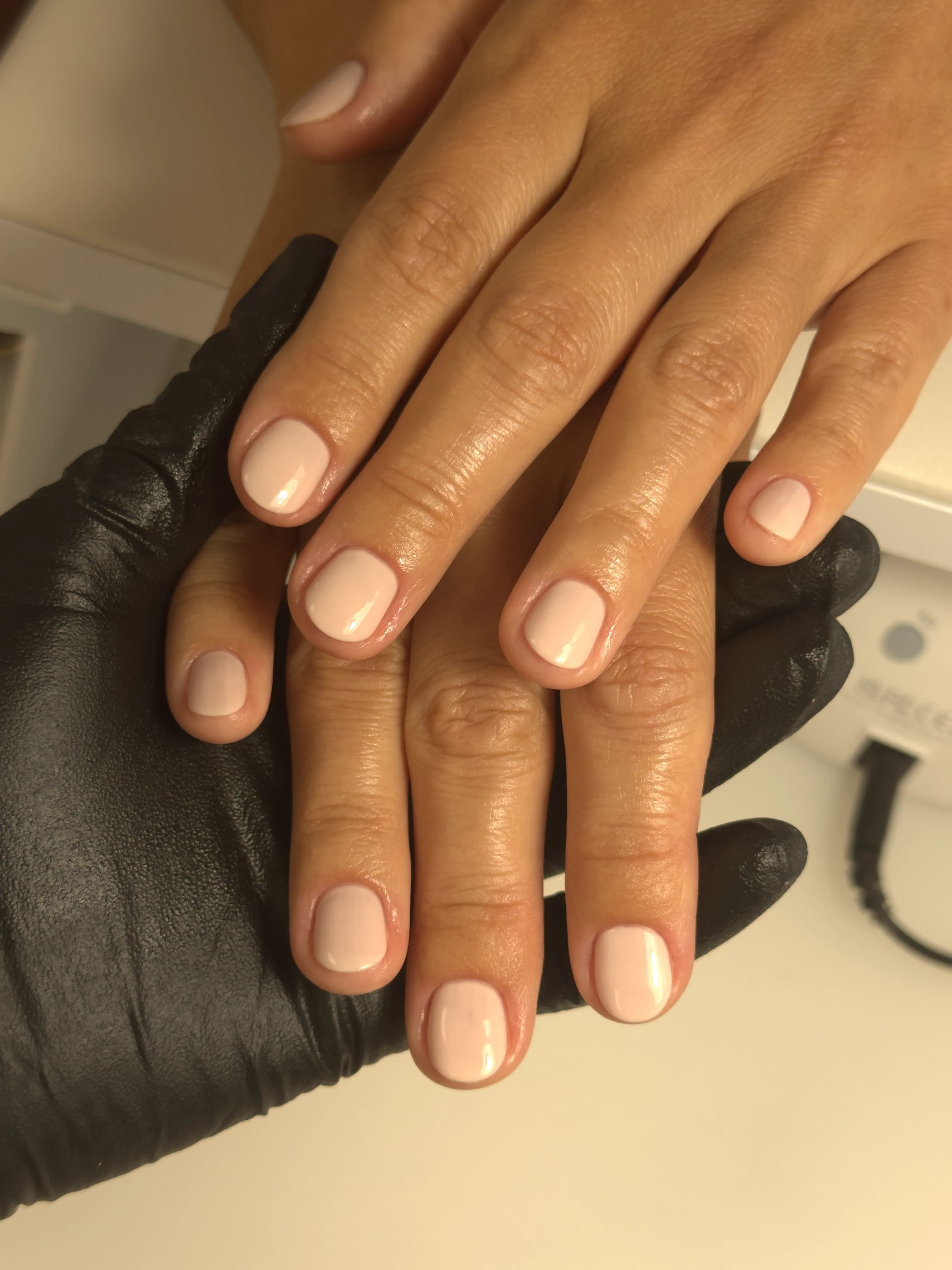 Light beige regular polish on short rounded nails beside a UV lamp, finished at My Beauty Space manicure bar in Mississauga.