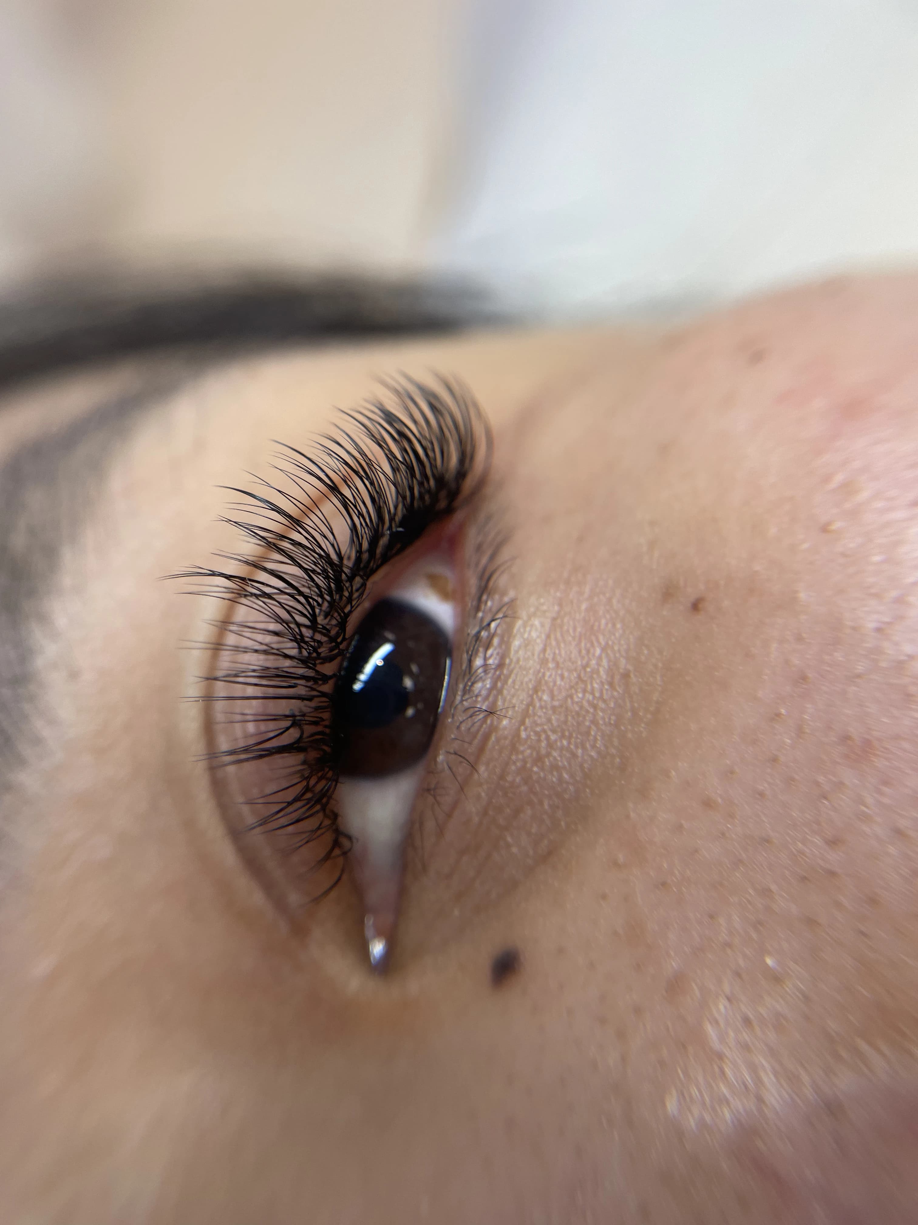 Side-angle light hybrid 2D lashes with pitch-black curl on deep brown eyes at My Beauty Space Mississauga.