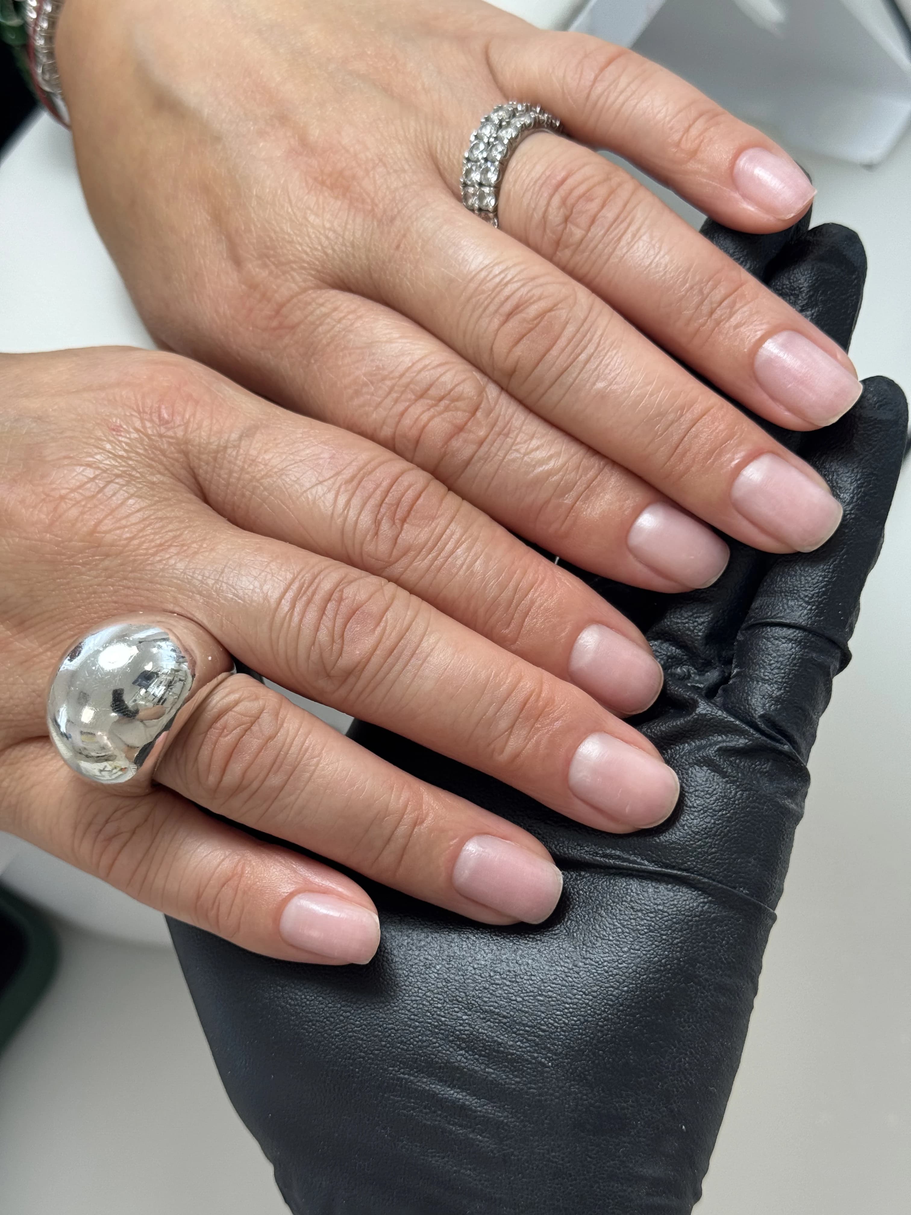Short squoval nails with a natural sheer pink buffed shine and silver rings, groomed at My Beauty Space in Mississauga.