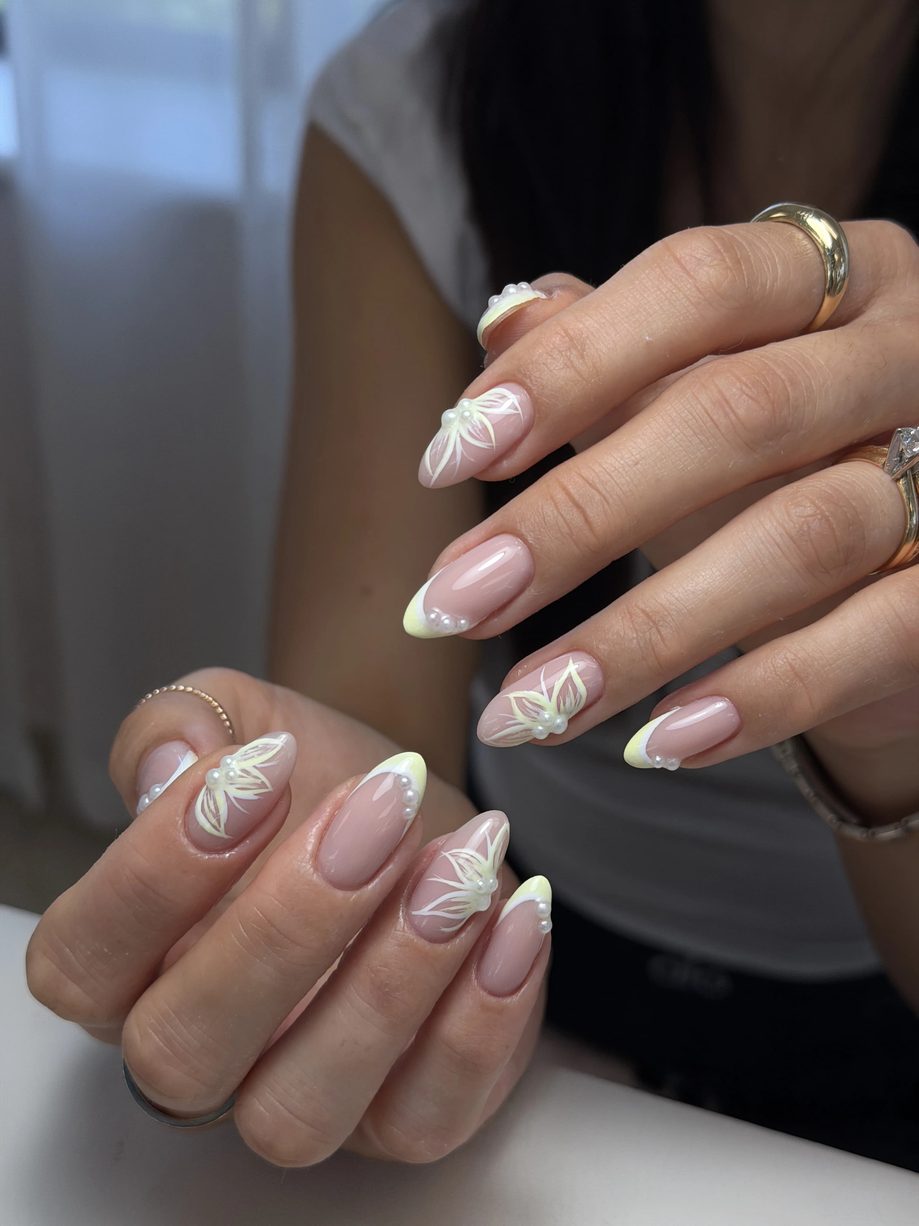 Custom nail art at My Beauty Space Mississauga: long almond nails with pastel yellow French tips, pearls, floral lines.