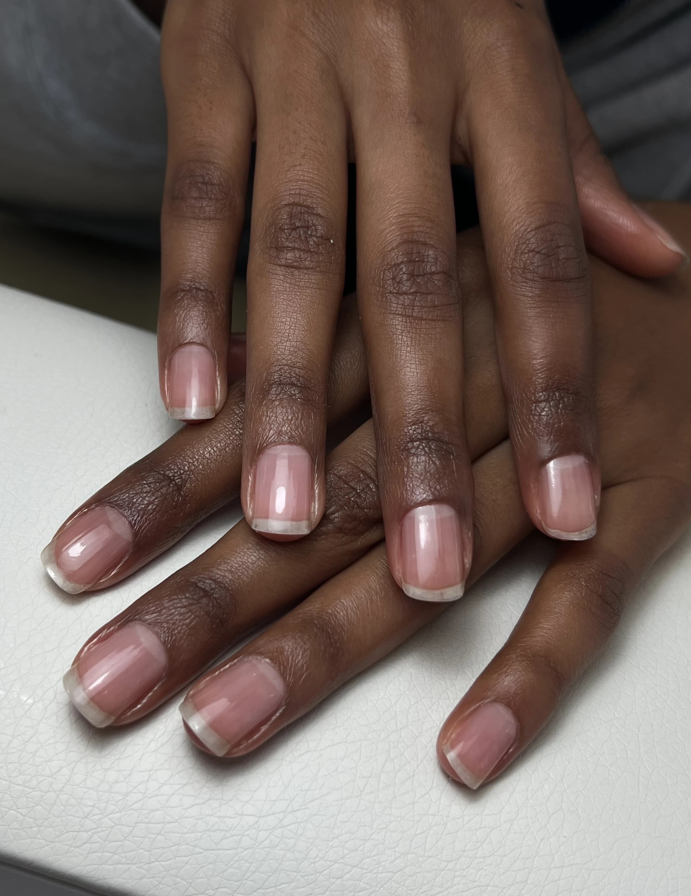 My Beauty Space Japanese manicure on short squoval nails with a high-gloss clear finish on deep-toned hands.